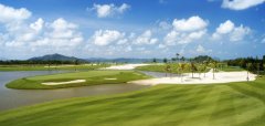 Golfové hřiště s vodními překážkami a palmami pod modrou oblohou