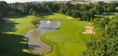 Golfové hřiště s jezírkem a fontánou obklopené stromy