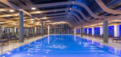 Interiérový bazén s lehátky a moderním osvětlením Lyttos Beach