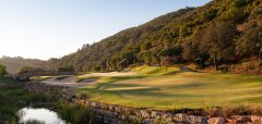 Golfové hřiště u kopce s vodním příkopem a mostem