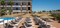Terasa s lehátky a slunečníky u bazénu hotelu La Cala