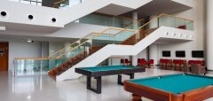 Interiér s kulečníkovými stoly a schodištěm ve Vidamar Resort Madeira