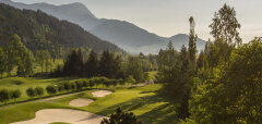 Golfové hřiště s pískovými bunkry a horským pozadím