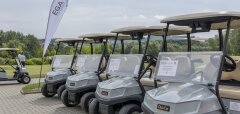Golfové vozíky zaparkované u golfového hřiště za oblačného dne