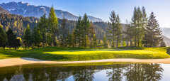 Golfové hřiště s jezírkem a horským pozadím