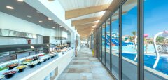 Interiér restaurace s výhledem na bazén a tobogány Lyttos Beach