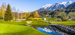 Golfové hřiště s jezírkem a zasněženými horami v pozadí