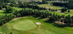 Golfové hřiště se zelení a pískovými bunkry v přírodním prostředí