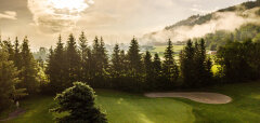Golfové hřiště s pískovými bunkry a stromy za úsvitu