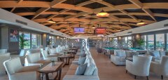 Interiér moderního lounge baru s pohodlnými sedačkami a dřevěným stropem