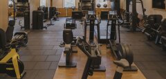 Interiér fitness centra s různými posilovacími stroji a kardio vybavením