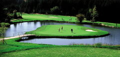 Golfové hřiště s jezírkem a hráči uprostřed vody