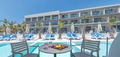 Terasa s stolem, židlemi a bazénem u hotelu Lyttos Beach