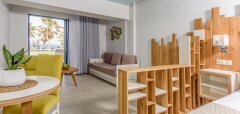 Interiér hotelového pokoje s výhledem na palmy u Lyttos Beach