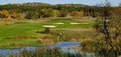 Golfové hřiště s jezírkem a podzimní krajinou v pozadí