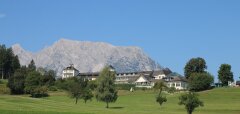 Golfové hřiště s budovou a horami v pozadí