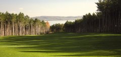 Golfové hřiště s výhledem na jezero a lesy kolem