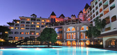 Hotel Sirene Belek večer s osvětleným bazénem a mostkem
