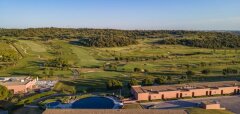 Golfové hřiště s budovami a bazénem za jasného dne