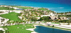 Pohled na golfové hřiště u oceánu s palmami a jezírkem