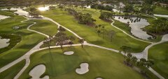 Letecký pohled na golfové hřiště s jezery a stromy při západu slunce