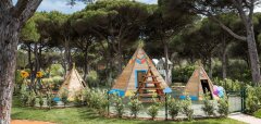 Dětské hřiště s dřevěnými teepee stany a houpačkami v lese