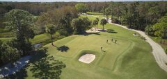 Golfové hřiště s hráči a okolními stromy v PGA National Resort