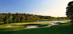 Golfové hřiště s pískovými bunkry a jezírkem za soumraku