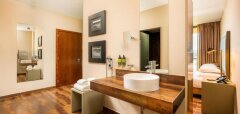 Interiér hotelového pokoje s umyvadlem a pohledem do ložnice NAU Morgado Golf & Country Club