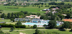 Golfové hřiště s bazénem a budovami v zelené krajině