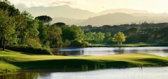 Golfové hřiště s jezírkem a stromy v pozadí