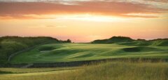 Golfové hřiště při západu slunce s kopci a trávou