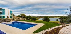 Bazén u moderního domu s výhledem na jezero a krajinu