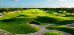 Golfové hřiště s bunkry a zelenou trávou za slunečného dne
