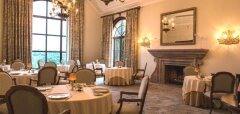 Interiér elegantní restaurace s krbem a kulatými stolky