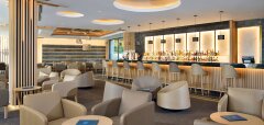 Moderní hotelový bar s pohodlnými křesly a osvětleným barem