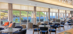 Interiér hotelové restaurace s výhledem na moře a zeleň
