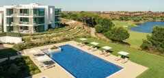 Bazén u moderního apartmánového domu s výhledem na golfové hřiště a jezero