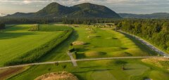 Golfové hřiště s kopci a lesy v pozadí