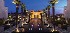 Noční pohled na osvětlenou cestu s palmami a fontánami ve Four Seasons Hotel Marrakech