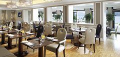 Interiér elegantní restaurace s uspořádanými stolky a židlemi