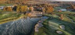 Golfové hřiště s jezírkem a podzimní krajinou v pozadí