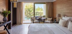 Pokoj hotelu s manželskou postelí a výhledem na terasu s přírodou