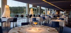 Interiér elegantní restaurace s prostřenými stoly a výhledem ven