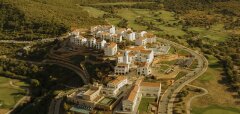 Letecký pohled na resort s bílými budovami a golfovým hřištěm