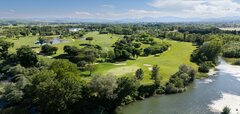 Golfové hřiště u řeky s okolní zelení a stromy