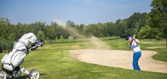 Golfista hrající z písečného bunkeru na golfovém hřišti