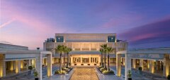 Moderní vstup do hotelu s palmami za soumraku