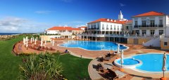 Bazény a budovy resortu s červenými střechami za slunečného dne