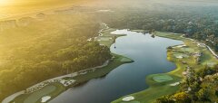 Letecký pohled na golfové hřiště u vody za svítání